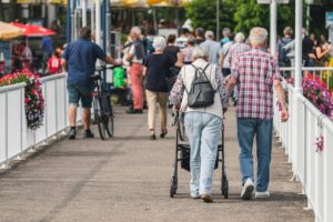 Elderly couple walking down a boardwalk hadn in hand