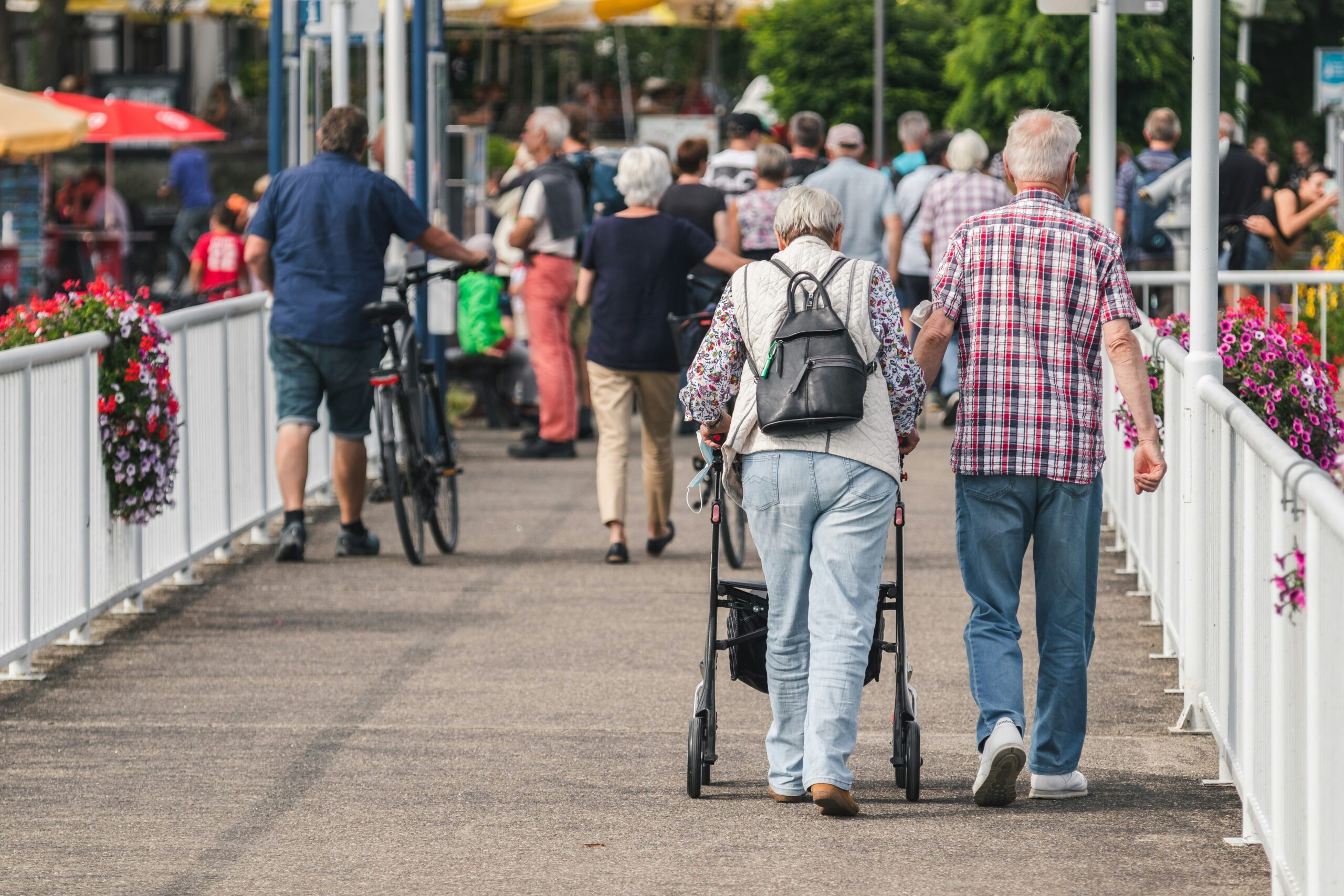 Elderly couple walking down a boardwalk hadn in hand